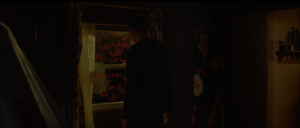 Kinsey (Bailee Madison) and Luke (Lewis Pullman) search an abandoned trailer in the trailer park and discover a window with "hello" written repeatedly on the glass in Strangers: Prey at Night