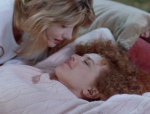 Fima (Maud Adams) hovers over Kim (Neith Hunter) before giving her a kiss in Silent Night, Deadly Night 4