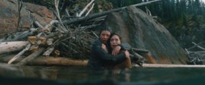 Joy (Hannah Emily Anderson) and Carmen (Madison Walsh) cower in the water while the creature in the woods hunts for them.